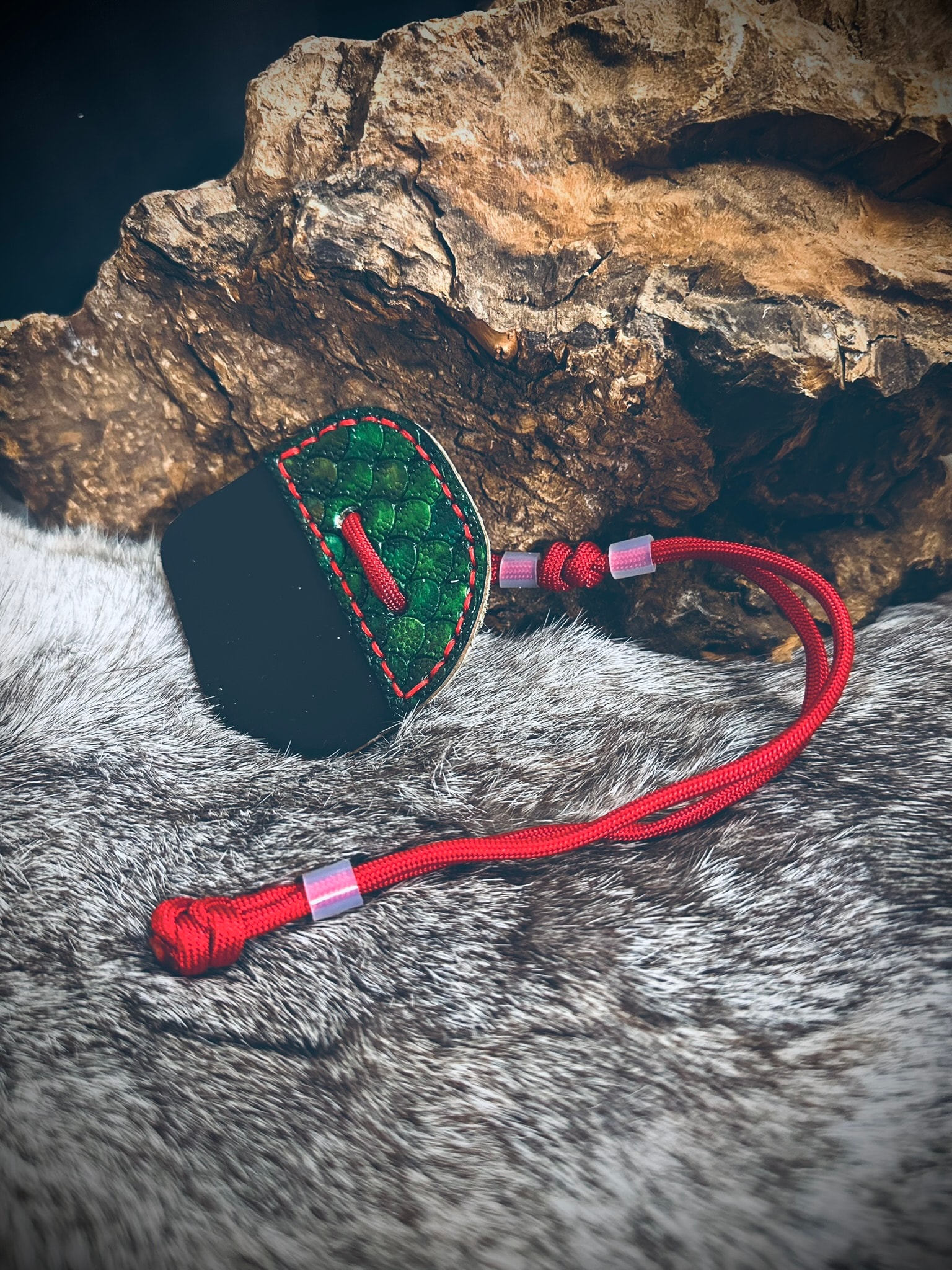 Dragon scale archery tab in green with bold red paracord and red stitching